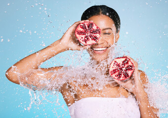 Beauty, skin care and woman with a pomegranate for healthy skin and diet on a blue background. Face...