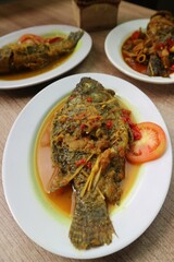 fried fish served with curry sauce and fresh tomato slices
