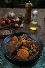Indonesian beefsteak with potatoes served in a black bowl