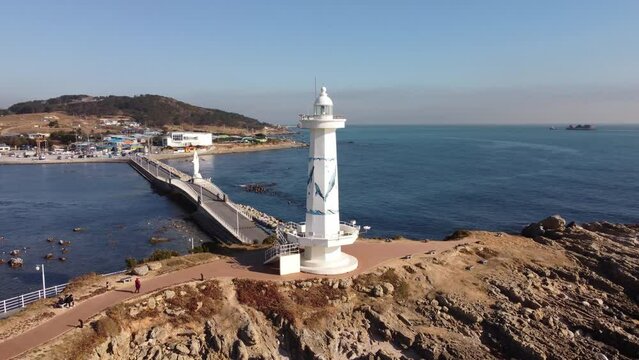Aerial view of a drone turning around the lighthouse of Seuldo in winter, near Ulsan, South Korea.