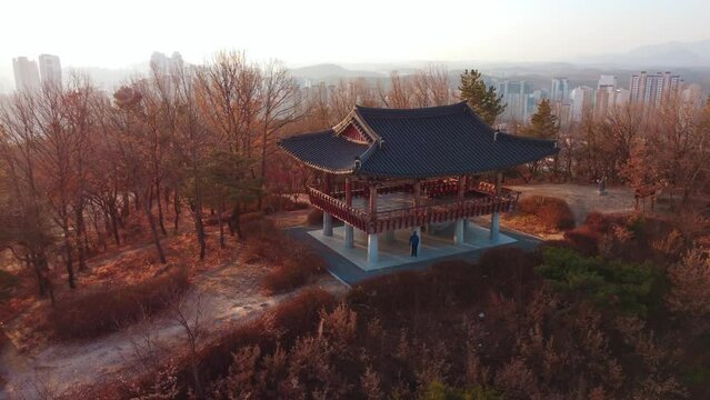 Drone view over a hanok on the Eunwolbong mountain peak and the cityscape of Ulsan, South Korea