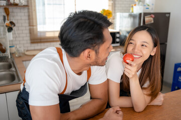 Happy Asian couple preparing food to cook breakfast in the kitchen And have fun cooking.