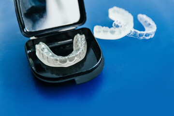 removable invisible aligner in a case on a blue background close-up