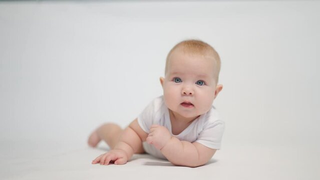 Portrait of a contented baby on a white background, concept stages of becoming a human being in a newborn state