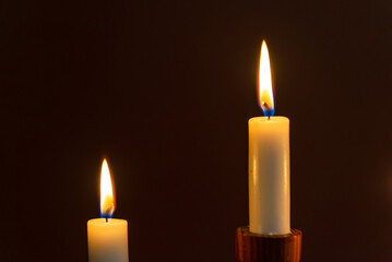 Two Candle flame on a dark background, symbol of prayer and remembrance.Religion concept.Closeup.