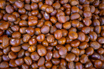 All-over brown texture of sweet chestnuts. There are many nuts available in the market.