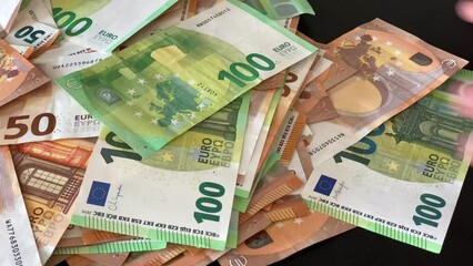 Hands push money on table from one side to the other 50, 100 euro banknotes bill