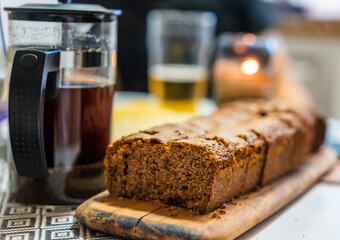 Homemade cupcake on a table on a wooden board next to a teapot with brewed tea