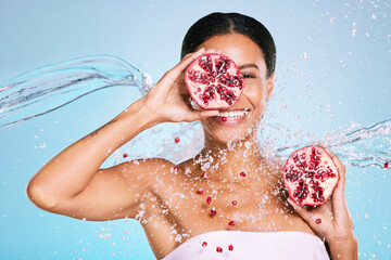 Pomegranate, skincare and woman portrait with beauty and healthy skin or diet on blue background. Face of aesthetic model person with water splash and fruit for sustainable facial health and wellness