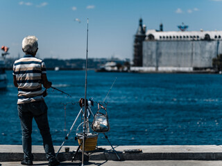 Fisherman, on the seaside, summer, fishing with patient