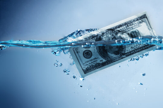 Money laundering. US Dollar banknotes in the water. Copy space.