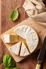 Brie, soft cheese on cutting board. Cheese board.