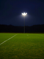 Training ground with grass illuminated by modern powerful LED lights. Efficient modern technology. Nobody.