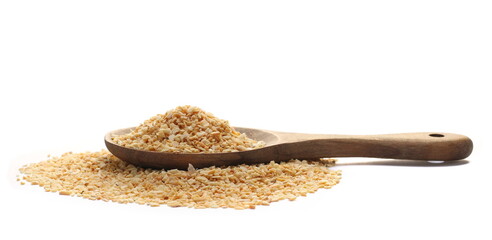 Chopped dry garlic pile in wooden spoon, isolated on white, side view