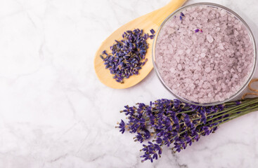 Obraz na płótnie Canvas Sea salt with lavender flowers in a bowl on a white marble background. Spice. Bath salt with lavender extract and aroma. Spa procedures. Skin care concept. Beauty