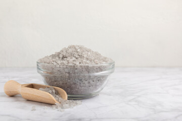 Sea salt in a bowl on a white marble background. Spice. Bath salt. Spa procedures. Skin care concept. Beauty