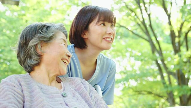 散歩に出かける車椅子のシニア女性と女性介護士