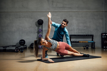 Trainer showing right position to do abs in a gym hiit class.