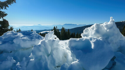Natural snow formations with scenic view of alpine meadows, hills and forest seen from hiking trail...