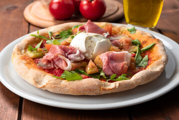 Deliziosa pizza condita con pomodoro fresco, mozzarella di bufala, rucola e prosciutto crudo, cibo italiano