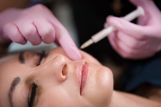 Beautician in a beauty salon makes injections with a syringe. Anti aging treatment. Skin care and rejuvenation treatments.