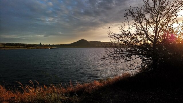 evening scenery of mountain hněvín with a castle and lookout tower Hněvín in sunset sun shine colours above lake Most and  city Most in czech republic	