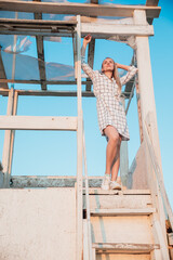 beautiful blonde stands on the wooden stairs of the house