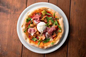 Deliziosa pizza condita con pomodoro fresco, mozzarella di bufala, rucola e prosciutto crudo, cibo italiano