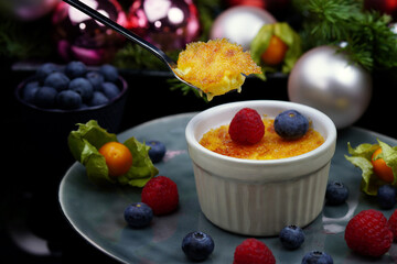 Dessert cream Brule, with berries on a black background.Homemade food.