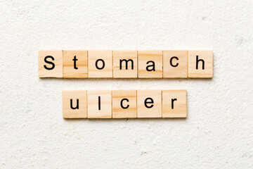 stomach ulcer word written on wood block. stomach ulcer text on table, concept