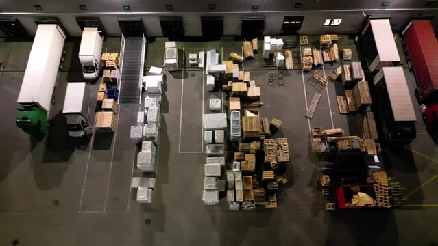 Flying above illuminated with lights storage place, distribution center and storehouse at night. International logistic and depository center shipping, transporting warehousing goods