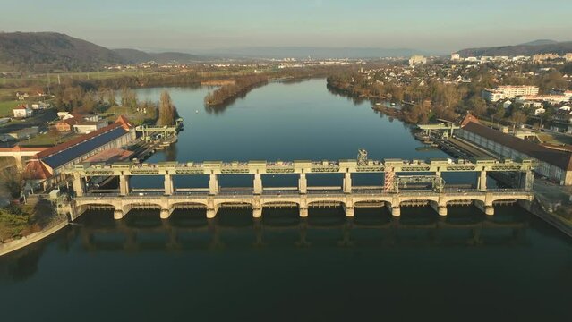 Person on a bicycle driving over the Hydro power plant over the Rhine in Augst between Switzerland and Germany. Backwards drone dolley shot