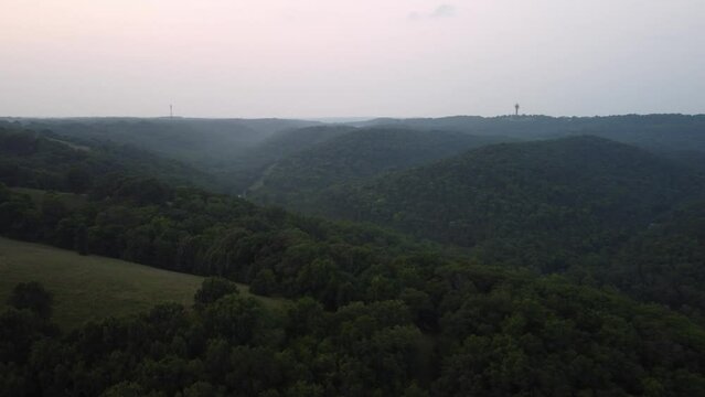Aerial shot over a forest full of trees on a cloudy and foggy day in Branson, MO