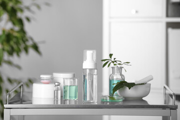 Many containers and glass tubes with leaves on white table indoors
