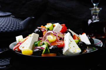 Greek salad on a black background. Homemade food. Food in a restaurant.