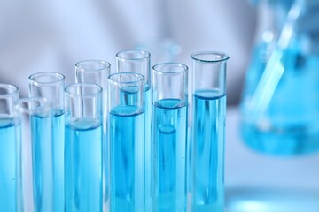 Test tubes with light blue liquid in laboratory, closeup