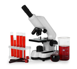 Laboratory glassware with red liquid and microscope isolated on white