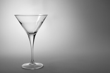 Elegant empty martini glass on grey background. Space for text