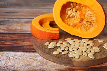 Fresh pumpkin and vegetable seeds on wooden table, closeup. Space for text