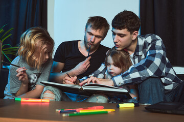 Staged photo. Homosexual couple and their children, two cute girls, at home.   Everyone is sitting...