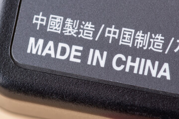Fototapeta premium Close up shot of electric charger with inscription Made in China. Concept of production of electronics in China