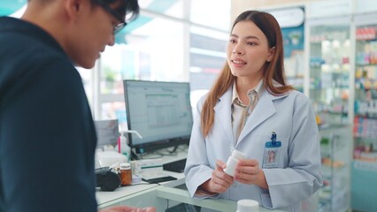 Fototapeta premium Professional asian woman pharmacist waring white uniform helping customer with medicine recommendation in drugstore