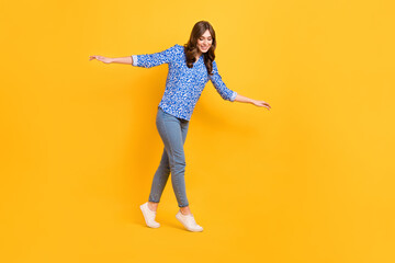 Fototapeta na wymiar Full size profile photo of pretty satisfied girl carefully walk balancing empty space rope isolated on yellow color background