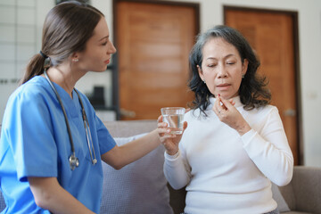 Portrait of a female doctor giving medicine to an elderly patient.