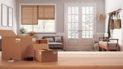Wooden table, desk or shelf with stack of cardboard boxes over japandi scandinavian living room with rattan furniture, moving house concept with copy space