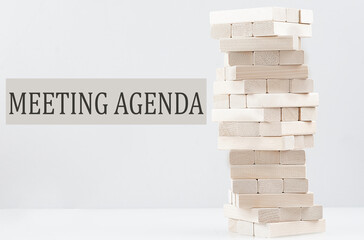 MEETING AGENDA text with wooden block stack on white background , business concept