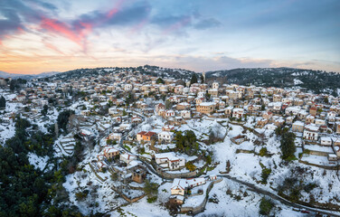 Panoramic aerial view of the snow covered village of Lafkos, South Pelion, Greece, during a winter sunset