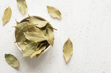 Dried bay leaves in bowl on rustic background, Spices and herbs concept (Laurus nobilis)