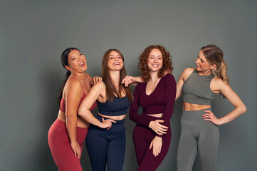 Group of four young women in sports clothes in studio shot