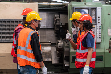 Foreman is taking orders in the factory. Factory worker and engineer as team. Engineer men wearing...